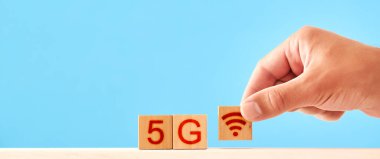5G konsepti. Adam 5g yazıtındaki tahta blokları istifliyor.