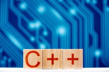 C + + konsepti. devre kartı parçalı mavi arkaplan üzerinde c + + + yazılı tahta bloklar