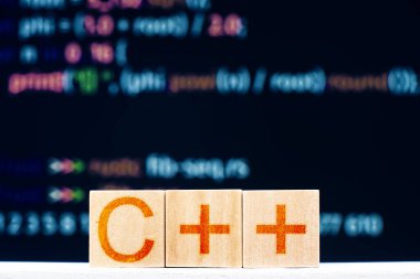 C + + konsepti. Arkaplanda C + + yazılı tahta bloklar ve program kodu