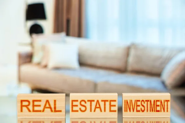 房地产投资 带有题词的木块 背景是带公寓的房地产投资 — 图库照片