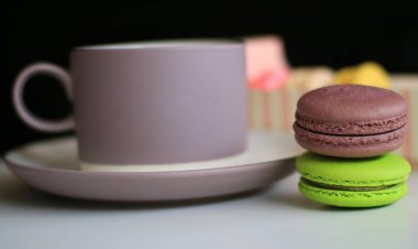 Renkli macaron ve içecek bir fincan.