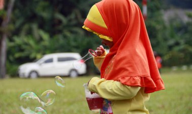 Bogor, Endonezya - 14 Nisan 2018: sabun köpüğü Bogor botanik bahçelerinde üfleyen Endonezya çocuk. 