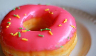 Beyaz arka plan ile lezzetli pembe çörek.