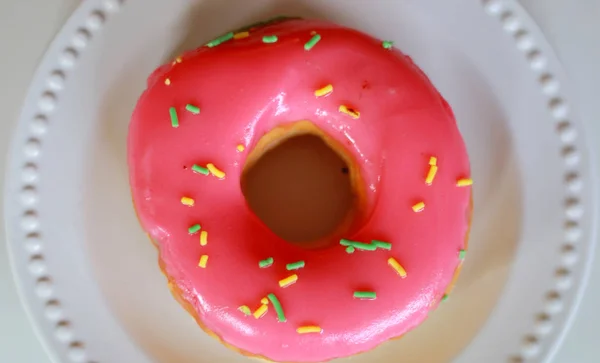 Delicious pink doughnut with white background.