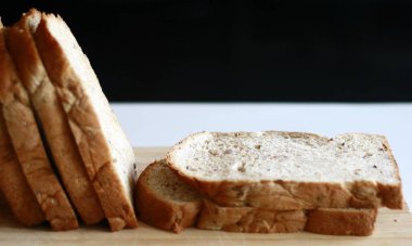 Dilim beyaz ekmek ahşap tahta üzerinde.