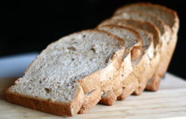 Dilim beyaz ekmek ahşap tahta üzerinde.