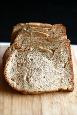 Dilim beyaz ekmek ahşap tahta üzerinde.