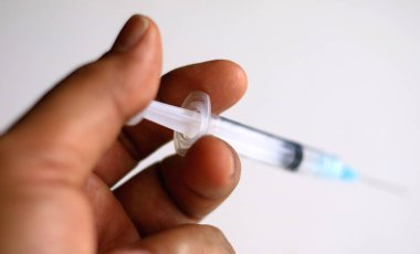 Bir el, bir enjeksiyon için hazır şırınga.