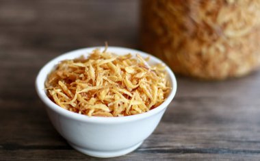 Ahşap arka plan üzerinde kızarmış kırmızı soğan. Tavuk, et veya balık yemeklerinin yanında Tepesi olarak kullanılabilir.