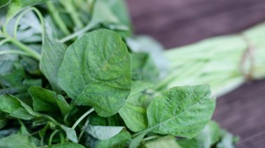 A bohça-in ahşap arka plan üzerinde taze ıspanak.