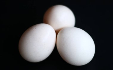 Kampung tavuk yumurta veya telur ayam kampung siyah arka plan üzerinde.