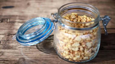 Ahşap arka planda bir kavanozda kızarmış fıstık.