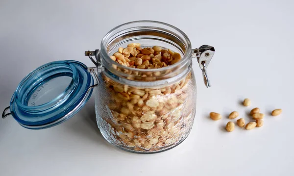 Beyaz arka planda bir kavanozda kızarmış fıstık.