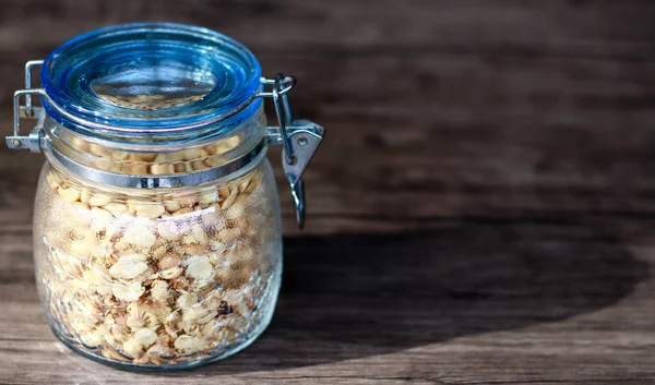 Ahşap arka planda bir kavanozda kızarmış fıstık.