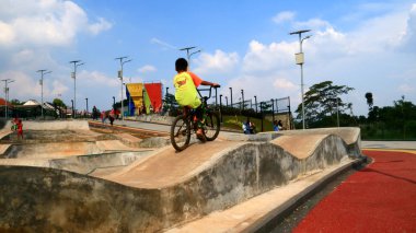Depok, Endonezya - 14 Nisan 2019: Grand Depok City, Batı Java'daki Alun-alun Depok'ta (yeşil açık alan) çocuk oyun bisikleti.