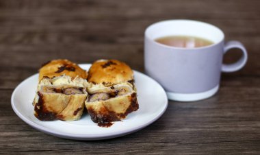 Muz çikolata pasta (bolen) ve ahşap arka plan üzerinde bir fincan çay. 