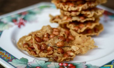 Fıstık Peyek tabakta. Peanut Rempeyek veya Peyek gevrek un meyilli tarafından fıstık ile pirinç unu yapılan derin yağda kızartılmış tuzlu Cava kraker olduğunu. Endonezya gıda.