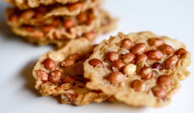 Beyaz arka planda Peanut Peyek. Peanut Rempeyek veya Peyek gevrek un meyilli tarafından fıstık ile pirinç unu yapılan derin yağda kızartılmış tuzlu Cava kraker olduğunu. Endonezya gıda.