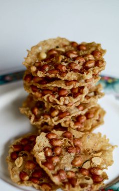 Fıstık Peyek tabakta. Peanut Rempeyek veya Peyek gevrek un meyilli tarafından fıstık ile pirinç unu yapılan derin yağda kızartılmış tuzlu Cava kraker olduğunu. Endonezya gıda.