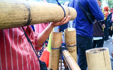Jakarta, Endonezya - 27 Haziran 2019: Orta Jakarta'daki at heykelinin (Arjuna Wijaya Heykeli) yakınındaki protestocular arasında sokak satıcıları (badeg geleneksel içki).