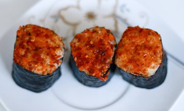 Beyaz arka plan üzerinde baharatlı ton balığı suşi rulo.