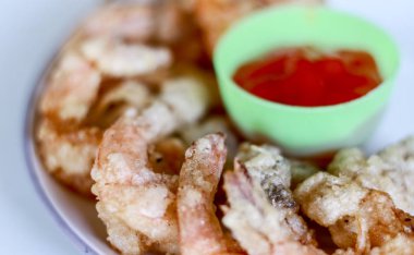 Beyaz arka planda kızarmış karides ve domates sosu.