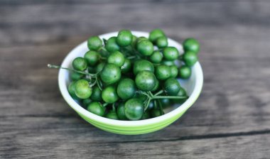 Ahşap arka planda Leunca veya Solanum nigrum. 