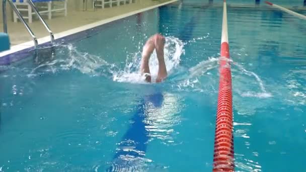 Slowmotion-skytte för en idrottare hoppa i poolen — Stockvideo