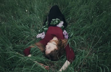 Yeşil çimenlerde yatan kız. Lila