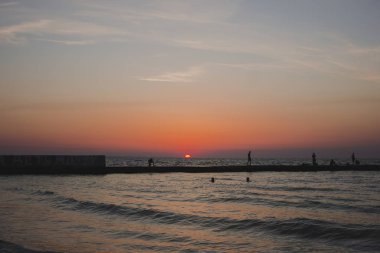 Parlak kırmızı güneşile kumlu kıyı 