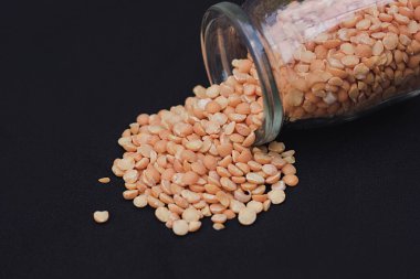 Bezelye kavanozu, üzerine bezelye dökülmüş karanlık bir yüzeye sade bir şekilde yerleştirilir.