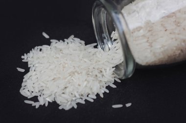 Pirinç temiz bir kavanozda saklanır ve gün boyunca karanlık bir yüzeye dökülen taneciklerle birlikte bir mutfak ortamında saklanır.