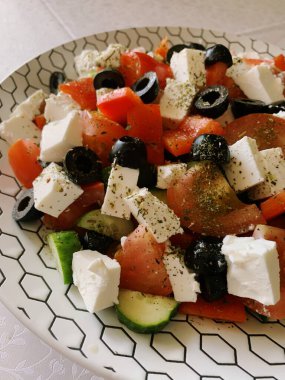 Domatesli taze salata, salatalık, zeytin ve sağlıklı bir yemek için bir kasede hazırlanmış beyaz peynir.