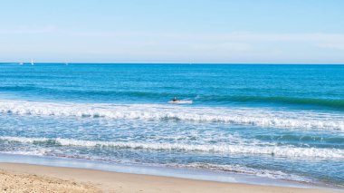 Genç adam denizde kürek yatılı için gidiyor.