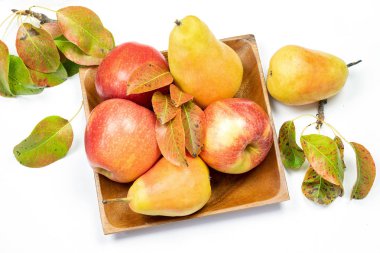 Beyaz arka plandaki ahşap kırsal plakada çiğ taze meyve var. Sonbahar hasat konsepti. 