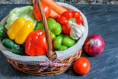 Siyah arka plandaki sepette taze taze sebzeler var..