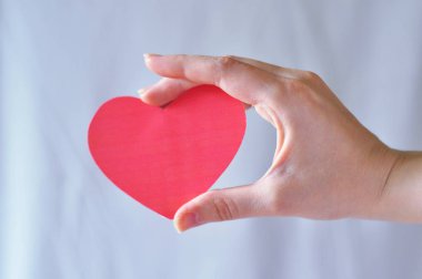 Eldeki küçük öğeler: makas, kağıt kalp, top.