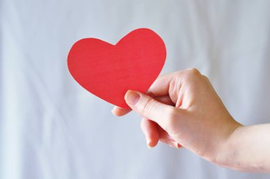 Eldeki küçük öğeler: makas, kağıt kalp, top.