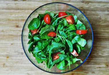 Taze ıspanak yaprakları. Ispanak salatası. Ispanak ve domates. Tahta kesme tahtası.