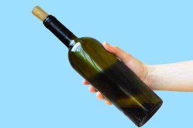 Elinde bir şişe kırmızı şarap. Elin bir şişe şarap tutuyor. Mavi arkaplan.