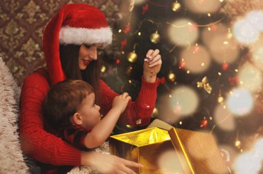 Genç güzel anne ile küçük oğlu bir hediye ile sihirli bir parlayan kutusuna arıyoruz.