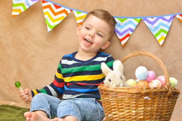 Roztomilý Chlapeček Zářivě Pruhované Raglán Sedí Košíkem Vnichž Jsou Velikonoční — Stock fotografie