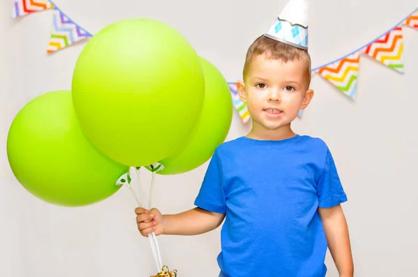 Menino Sorri Gorro Festivo Segura Três Balões Verdes Comemora Seu — Fotografia de Stock