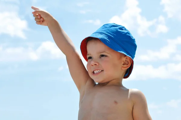 Słodki Chłopiec Niebieskim Kapeluszu Plaży Wskazuje Palcem Górę — Zdjęcie stockowe