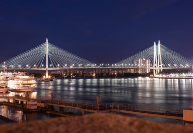 Gece şehrin kablo destekli köprüsü, fenerlerle aydınlatılmış.