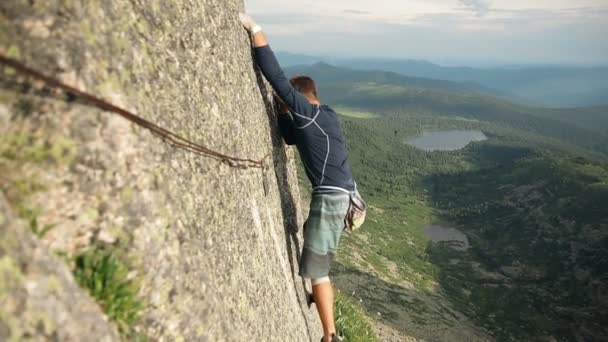 Un joven valiente solo trepa una roca sin seguro . — Vídeos de Stock