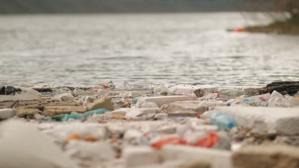 Vuilnis drijft in het water in de buurt van de kust. — Stockvideo