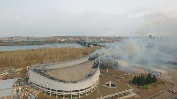 Красноярск, Россия - 08 мая 2018 года: Вид с воздуха на тушение крупного пожара на крыше стадиона . — стоковое видео