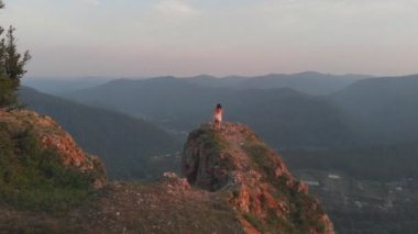 Bir uçurumun kenarında duran genç mutlu kadın.