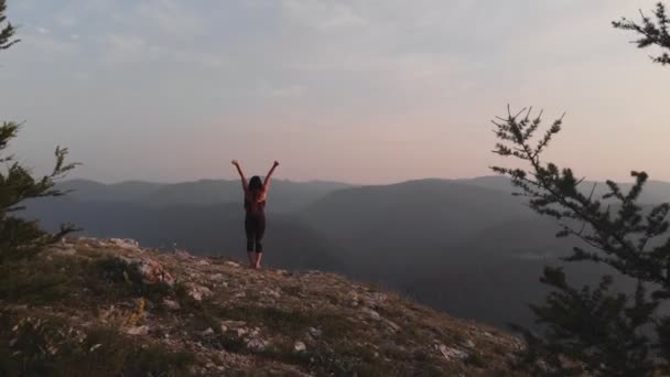 Joven mujer feliz de pie en el borde de un acantilado . — Vídeo de stock